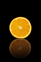 Half orange on a black reflective background