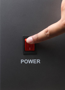 Asian male hand turning off red power switch