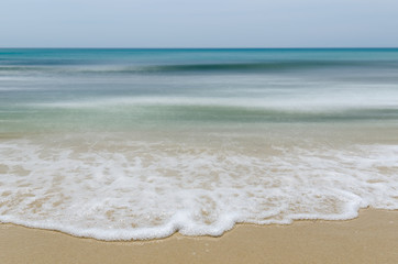 Seashore and smooth waves with sharp focus in foreground