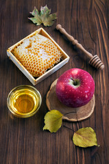 Still life with a honeycomb, apple and fall leaves
