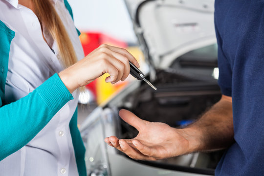 Customer Giving Car Keys To Mechanic