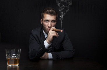 Zigarrenraucher mit Drink am Schreibtisch 