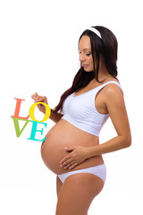 Label "Love" in the hands of pregnant woman isolated on vertical white background
