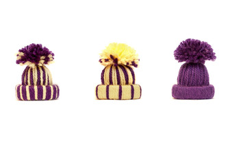 Warm knitted hats with big pompons on a white background