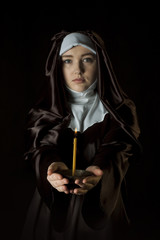 Nun holding candle.