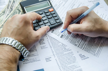 Cropped image of  Businessman calculating and checking tax - obrazy, fototapety, plakaty