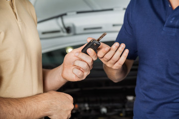 Client Giving Car Key To Mechanic