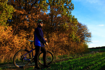 Obraz premium young adult cyclist riding mountain bike in the countryside
