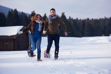 couple having fun and walking in snow shoes