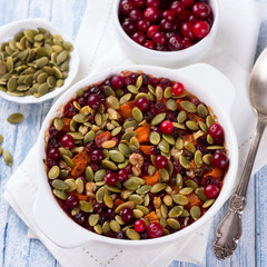 Millet pumpkin gratin with cranberries, walnuts and pumpkin seeds. Top view