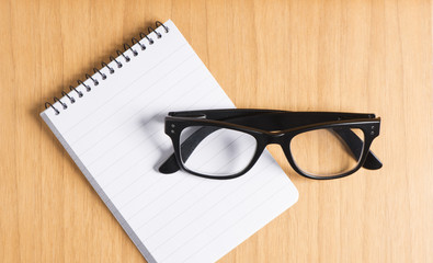 Empty notepad and glasses