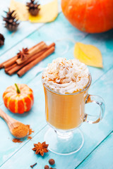 Pumpkin smoothie, spice latte with whipped cream. Turquoise wooden background.  