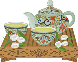 Kettle, small cups of green tea on a wooden table and flowers of tea.