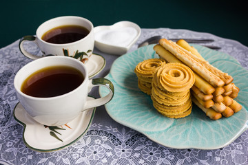 Double cups of hot black coffee with cookies 