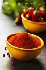 Paprika in a bowl and hot chili peppers