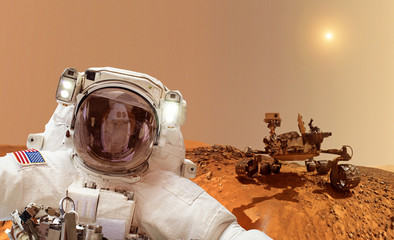 Astronaut with rover in background - Elements of this image furnished by NASA - obrazy, fototapety, plakaty