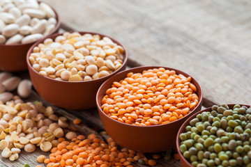 Bowls of cereal grains: red lentils, green mung, corn, beans and