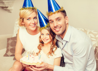 smiling family in blue hats with cake