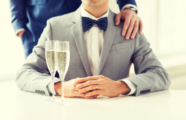 close up of male gay couple with champagne glasses