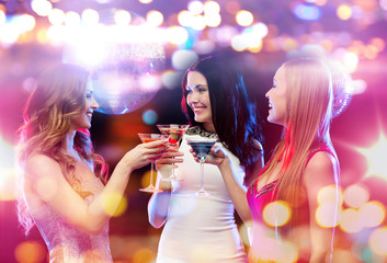 smiling women with cocktails at night club