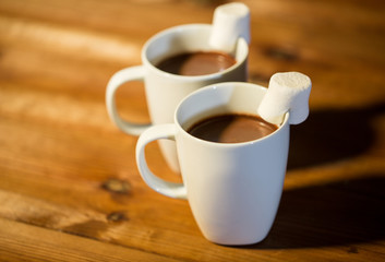 cups of hot chocolate with marshmallow on wood