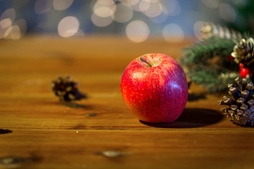close up of apple with fir decoration on wood