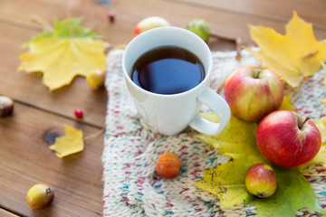 close up of tea cup on table with autumn leaves
