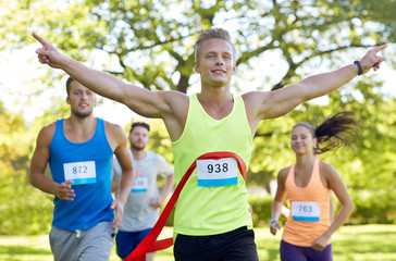 happy young male runner winning on race finish