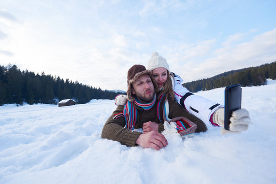 romantic couple have fun in fresh snow and taking selfie