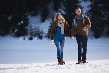 couple having fun and walking in snow shoes