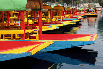Rows of Colorful boats on a canal in Xochimilco of Mexico.