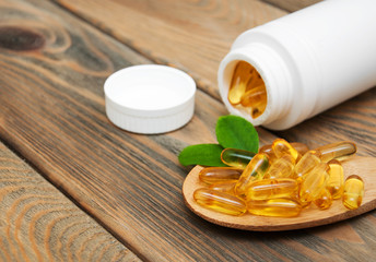 fish oil capsules in a spoon