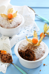 chocolate muffins in ceramic forms sprinkled with powdered sugar