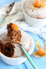 chocolate muffins in ceramic forms sprinkled with powdered sugar