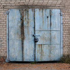Old weathered blue garage doors.
