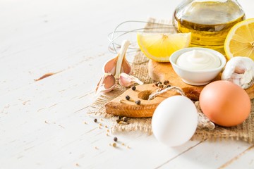 Mayonaise ingredients on white wood backgound