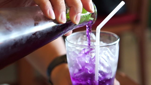Herb drink, Butterfly pea, Clitoria ternatea L. flower mixed with lime, lemon being poured in to the glass