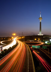 Fototapeta na wymiar Milad Tower and light trails from cars on the highways of Tehran.