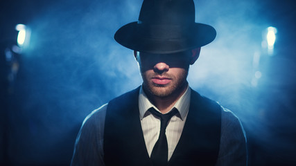man in a hat on a dark background - obrazy, fototapety, plakaty