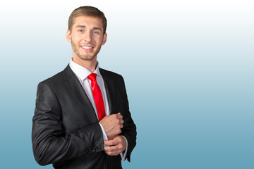 Confident young businessman buttoning cuff sleeves