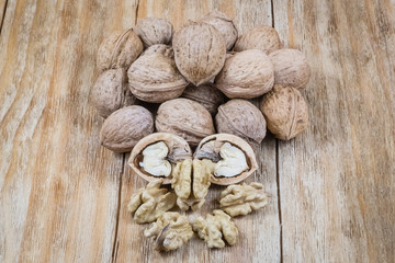 plenty of whole and shelled walnuts on a wooden
