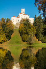 Obraz premium Castle of Trakoscan on the hill in autumn, Zagorje, Croatia, reflection on the lake