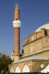 Fototapeta na wymiar Sofia, Bulgaria - minaret of Banya Bashi mosque, behind the clock tower of Central Sofia Market Hall