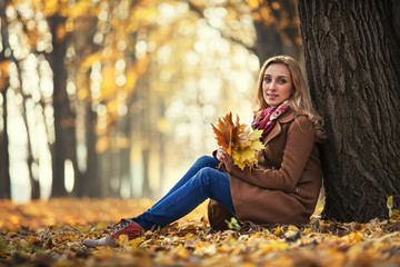 Young woman with autumn leaves