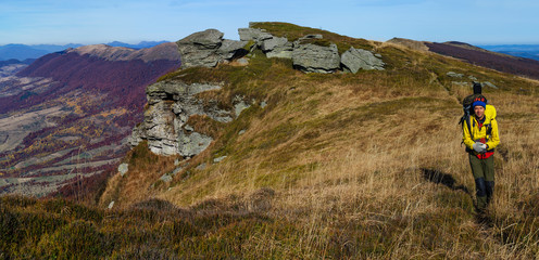 Tourist walks in autumn mountain landscape