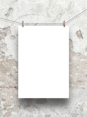 Vertical frame hung by clothes pin on grey scratched concrete wall background