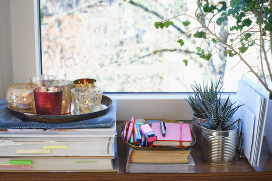 Books, candles and succulent plants on a windowsill