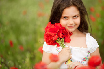 Close up of cute girl in poppy field holding flowers bouquet outdoors. Girl in poppies. Happy kid with poppies.