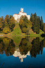 Fototapeta na wymiar Castle of Trakoscan on the hill in autumn, Zagorje, Croatia, reflection on the lake 