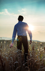 Calm businessman walking towards the sunset